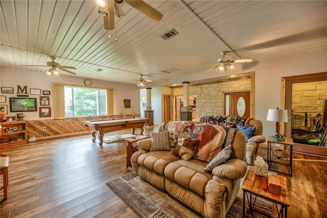 a room with pool table and windows