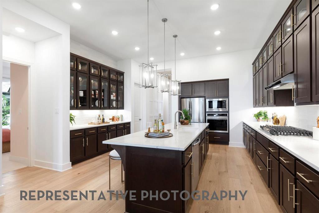2907 Messenger Street Forney, TX 75126 - Photo 6 of 40 a kitchen with granite countertop a sink cabinets and wooden floor