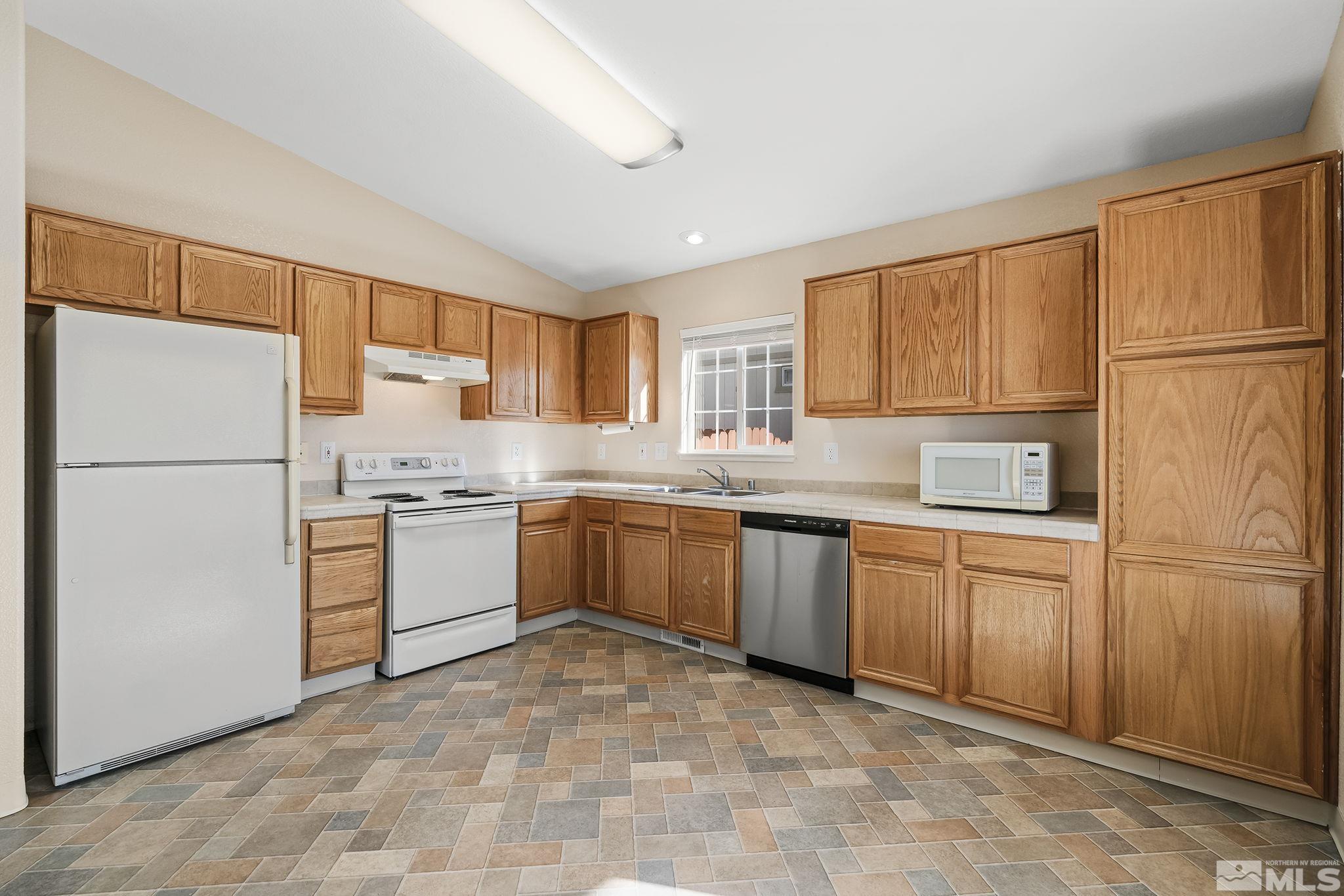 17765 Fortune Court Reno, NV 89508 - Photo 6 of 16 a kitchen with granite countertop stainless steel appliances and refrigerator
