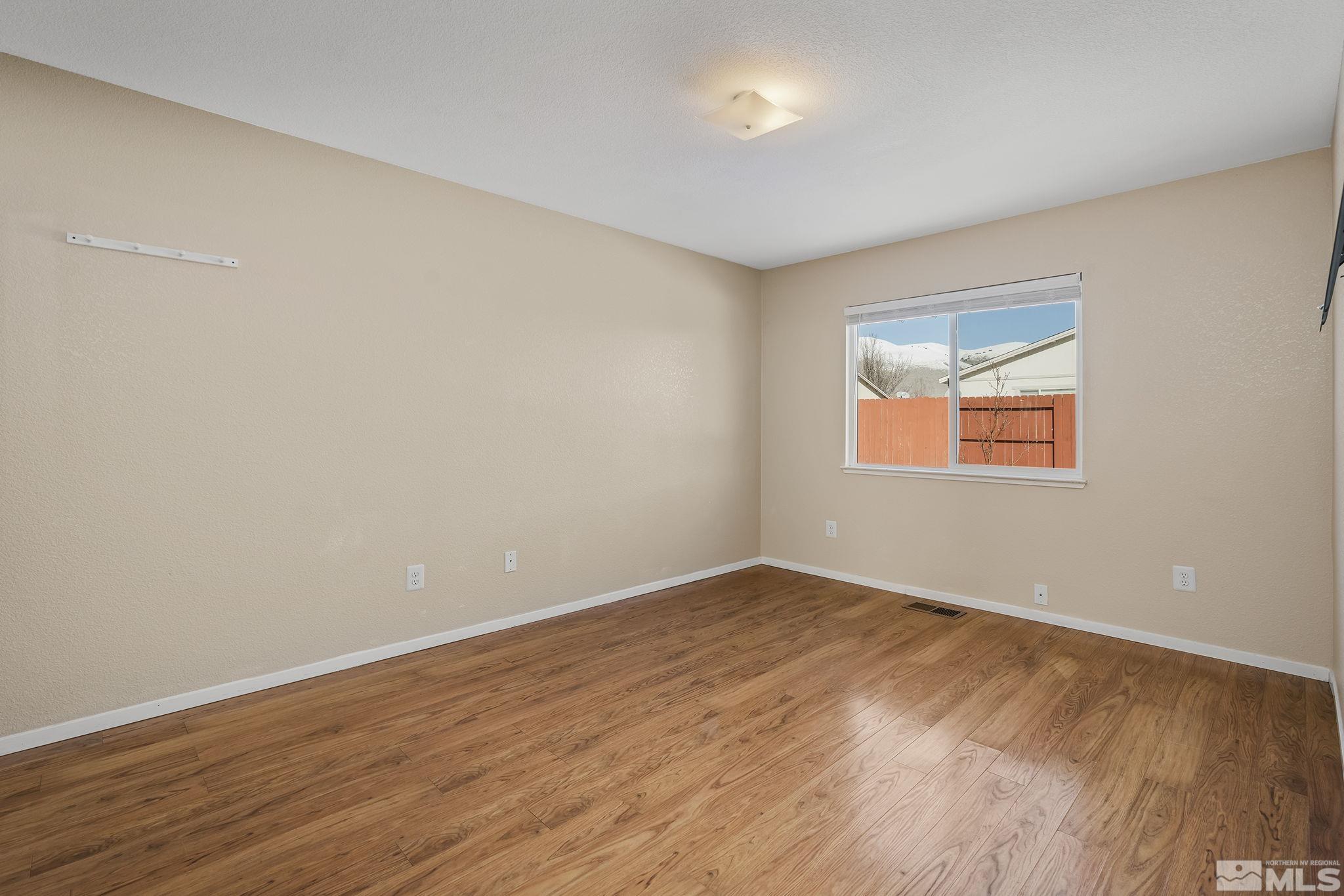 17765 Fortune Court Reno, NV 89508 - Photo 8 of 16 a view of an empty room with wooden floor and a window