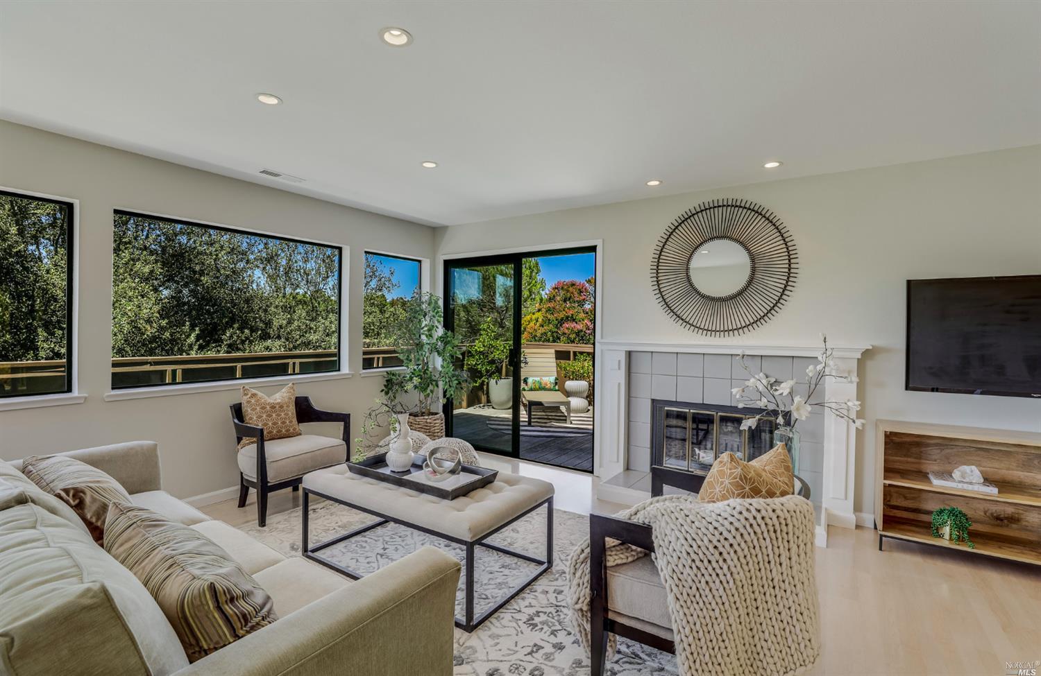a living room with furniture a fireplace and a floor to ceiling window