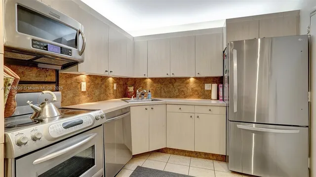 a kitchen with appliances a refrigerator and cabinets