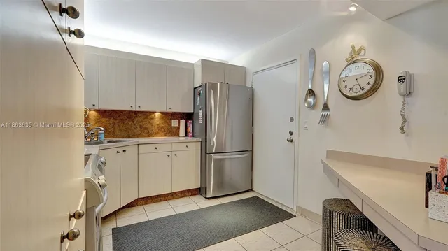 a kitchen with stainless steel appliances granite countertop a refrigerator a stove and a sink