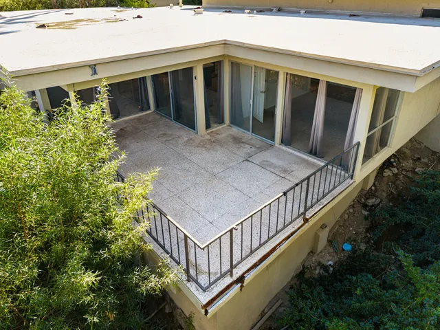 a view of a patio with plants and a lawn chairs