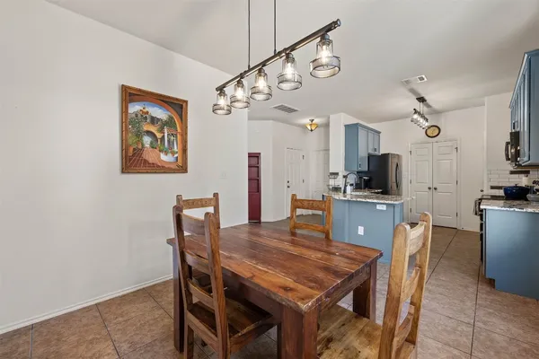 a view of a dining room with furniture and a kitchen view