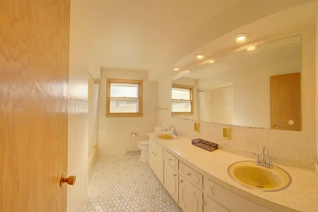 a spacious bathroom with a double vanity sink a mirror and a shower