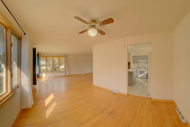a view of empty room with window and ceiling fan