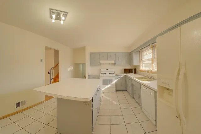 a large white kitchen with cabinets and a refrigerator