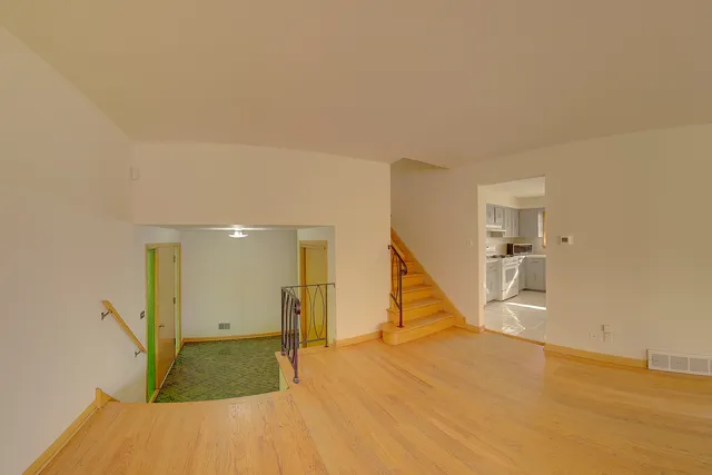 a view of a livingroom with wooden floor and a ceiling fan