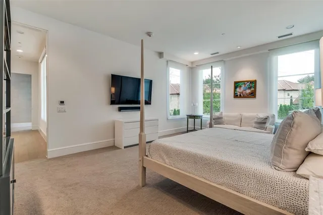 a spacious bedroom with a bed and a flat screen tv
