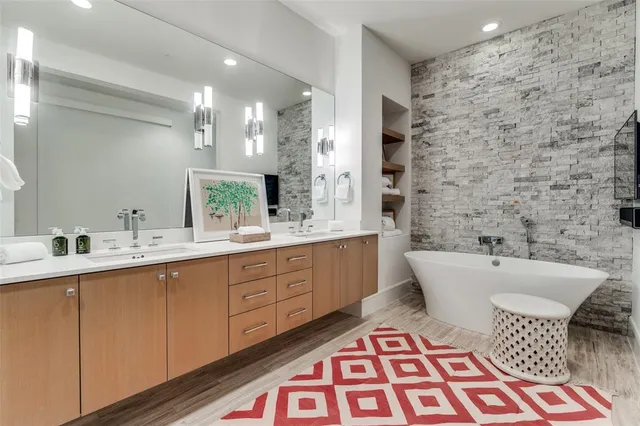 a spacious bathroom with a double vanity sink mirror and bathtub