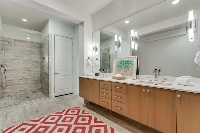 a bathroom with a double vanity sink mirror and shower
