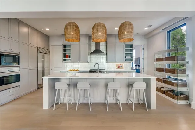 a kitchen with stainless steel appliances a stove a table and chairs