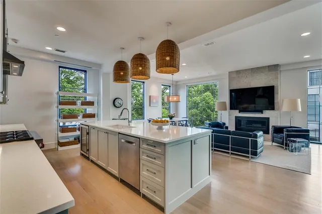 a kitchen with stainless steel appliances a stove and a living room