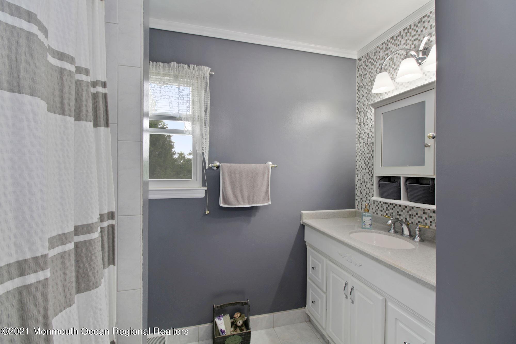 8 Derringer Drive Howell, NJ 07731 - Photo 22 of 33 a bathroom with a sink a vanity and mirror