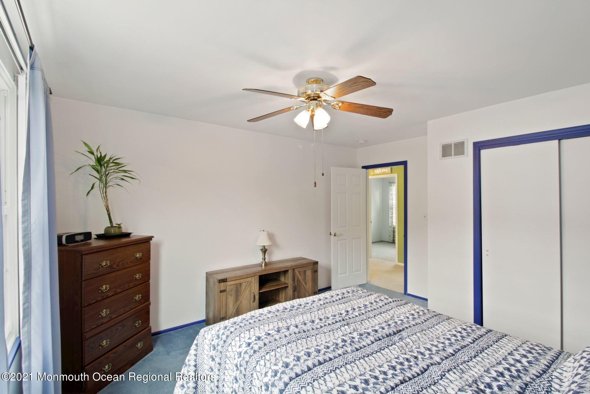 8 Derringer Drive Howell, NJ 07731 - Photo 24 of 33 a bedroom with a bed and a chandelier