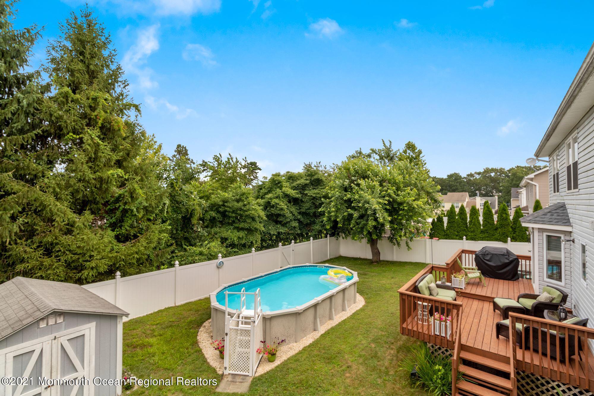 8 Derringer Drive Howell, NJ 07731 - Photo 33 of 33 a view of a swimming pool with lawn chairs and a fire pit