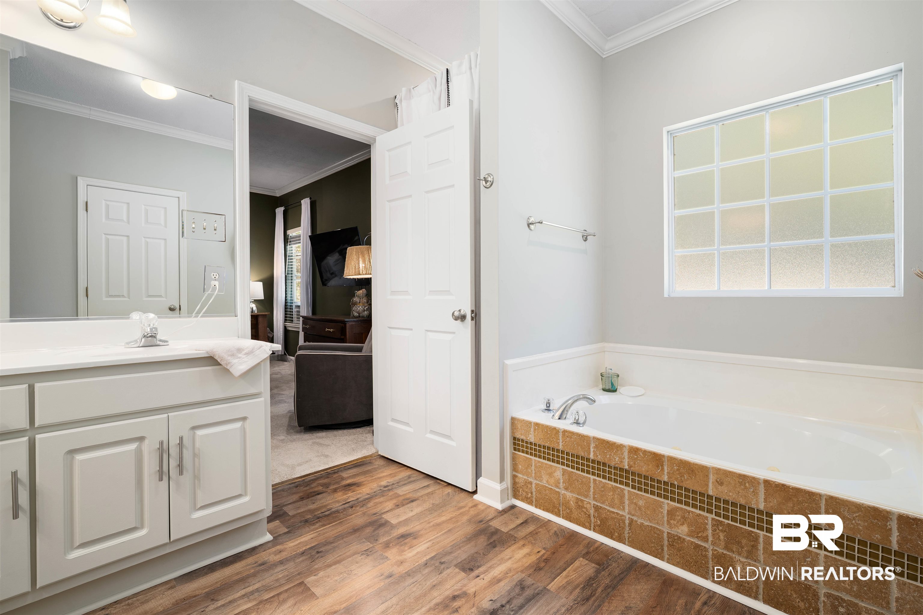 27288 Parker Lane Daphne, AL 36526 - Photo 15 of 29 Bathroom with vanity, crown molding, a garden tub, dark wood-style floors, and plenty of natural light