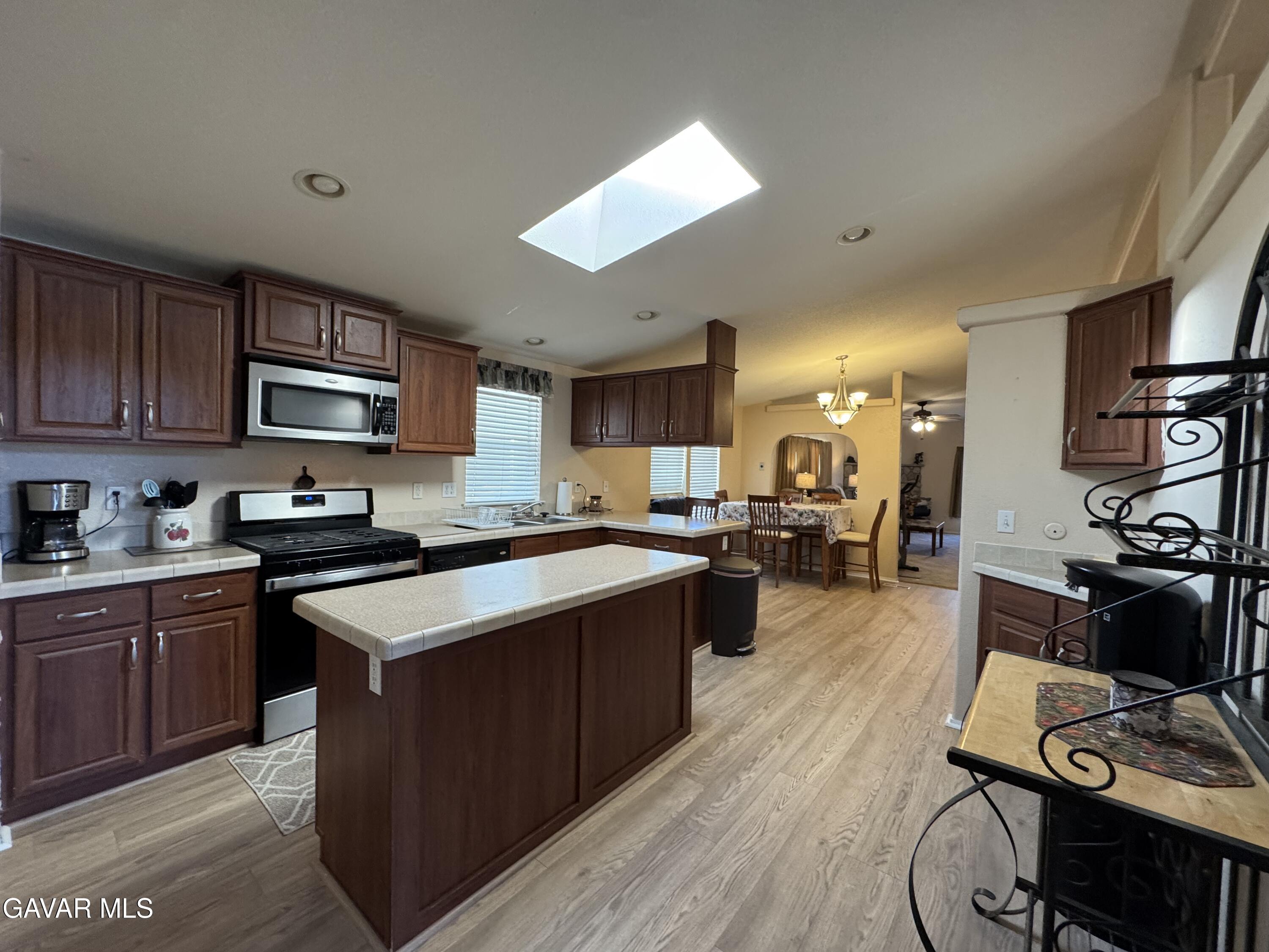 2000 Windflow Drive Rosamond, CA 93560 - Photo 13 of 48 a large kitchen with stainless steel appliances and wooden cabinets