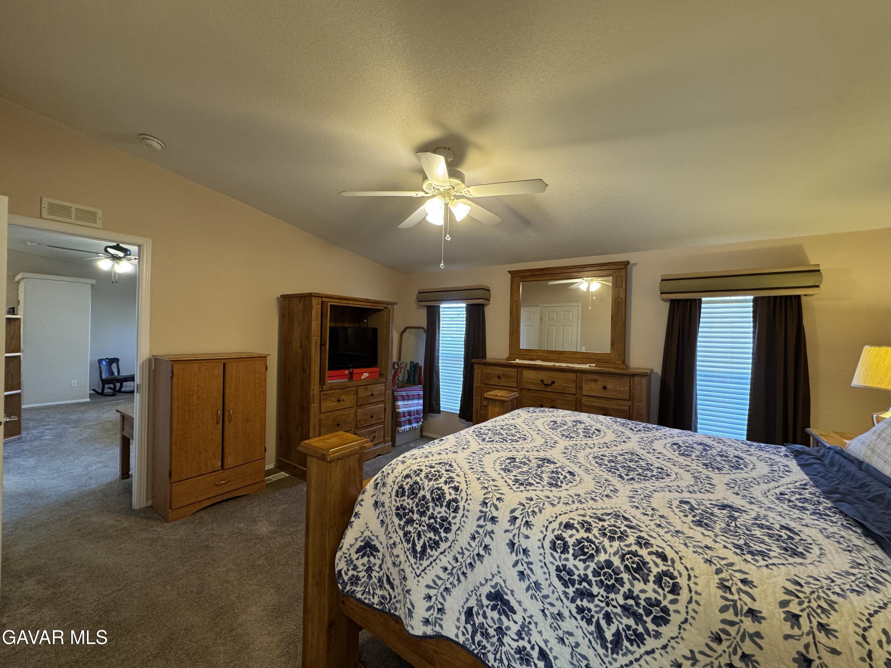 2000 Windflow Drive Rosamond, CA 93560 - Photo 23 of 48 a spacious bedroom with a large bed and a chandelier