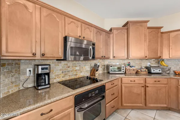 a kitchen with stainless steel appliances granite countertop a sink a stove and cabinets