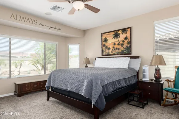 a bed sitting in a spacious bedroom next to a window