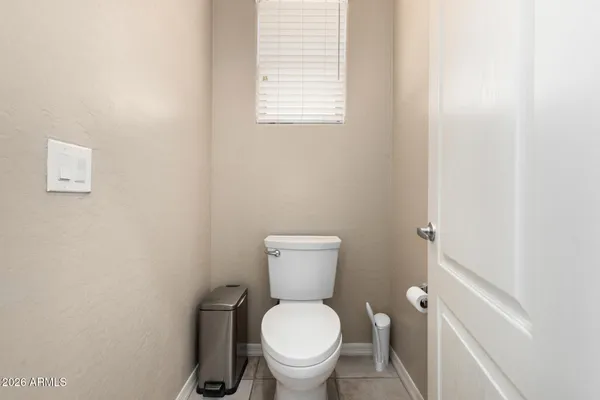 a white toilet sitting next to a white wall
