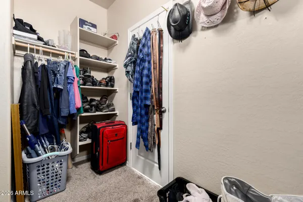 a view of walk in closet with clothes and shoes