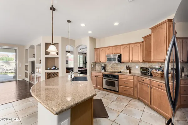 a kitchen with stainless steel appliances granite countertop a stove top oven a sink dishwasher and white cabinets with granite countertops