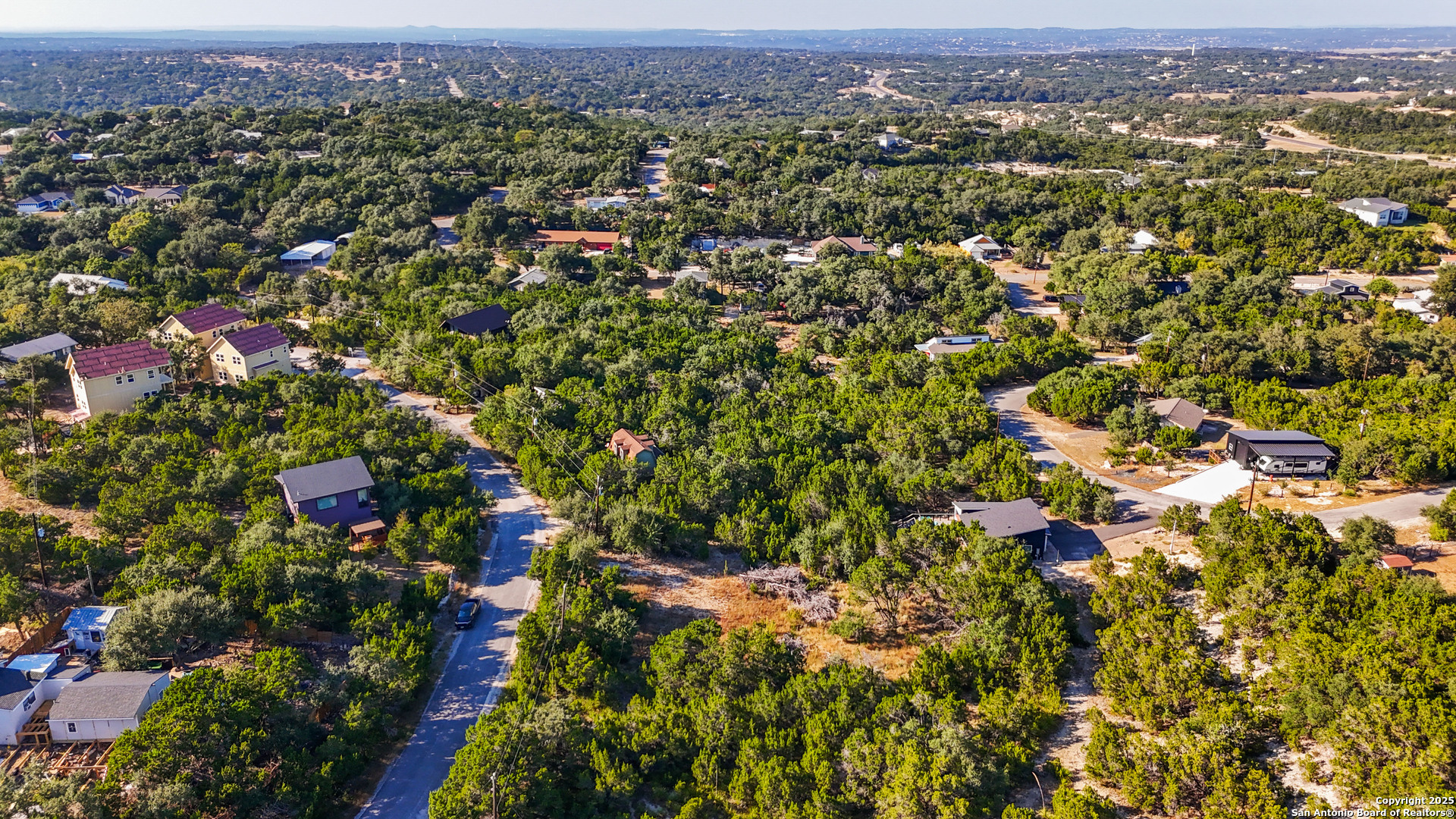 813 Valley Ridge Canyon Lake, TX 78133 - Photo 18 of 18 an aerial view of a houses with a lush green hillside
