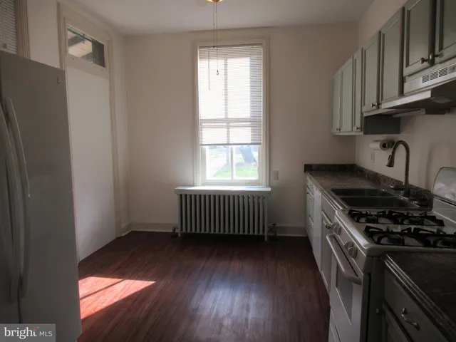 a kitchen with granite countertop a stove a sink and a window