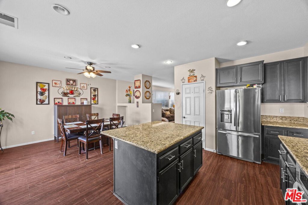 26692 Rim Creek Path, Unit PATHWAY Menifee, CA 92584 - Photo 11 of 41 a kitchen with a refrigerator and wooden floor