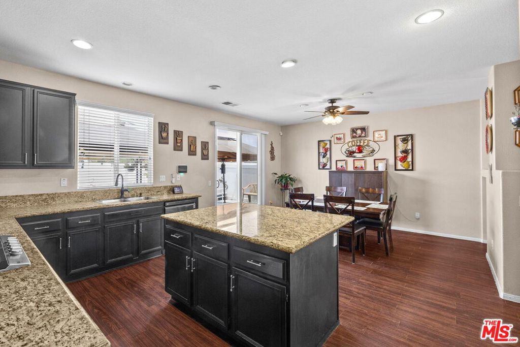 26692 Rim Creek Path, Unit PATHWAY Menifee, CA 92584 - Photo 12 of 41 a kitchen with granite countertop a sink stove and wooden floor