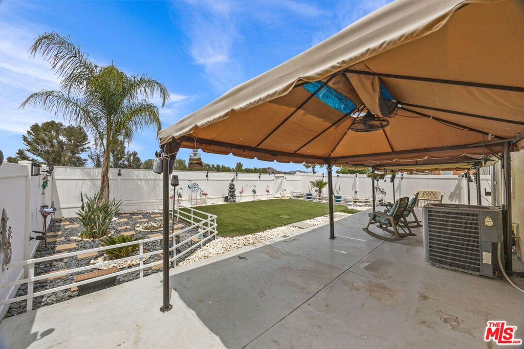 26692 Rim Creek Path, Unit PATHWAY Menifee, CA 92584 - Photo 30 of 41 a view of a patio with a table and chairs under an umbrella