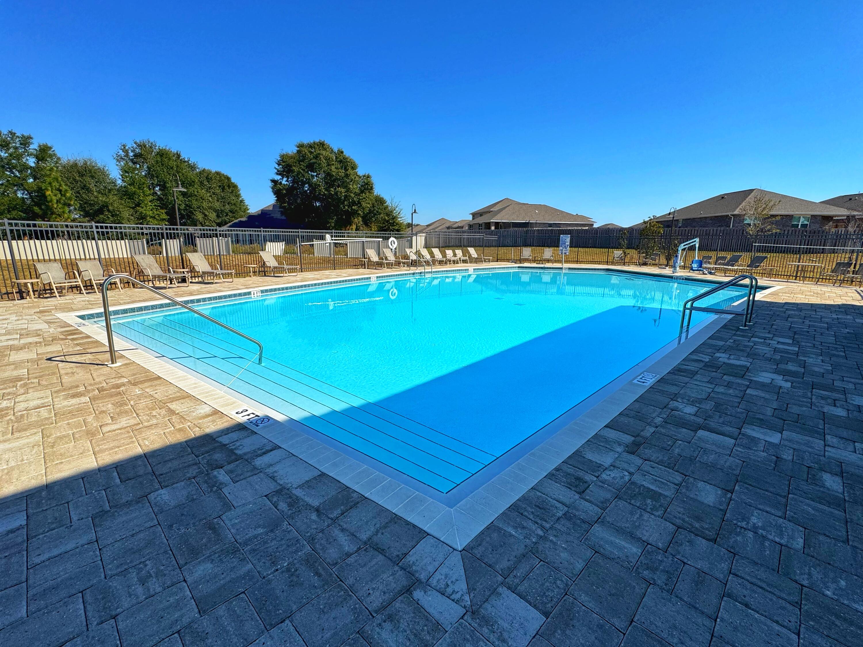 4614 Honor Guard Way Crestview, FL 32539 - Photo 46 of 48 a view of a pool with lawn chairs under an umbrella
