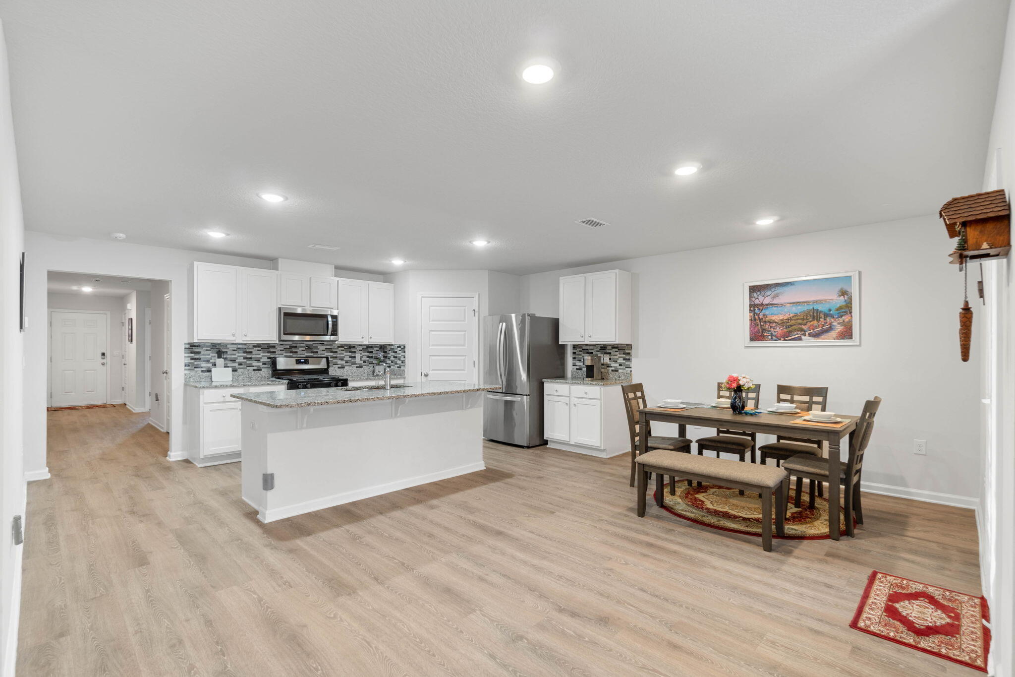 4614 Honor Guard Way Crestview, FL 32539 - Photo 10 of 48 a kitchen with a sink and white cabinets with wooden floor