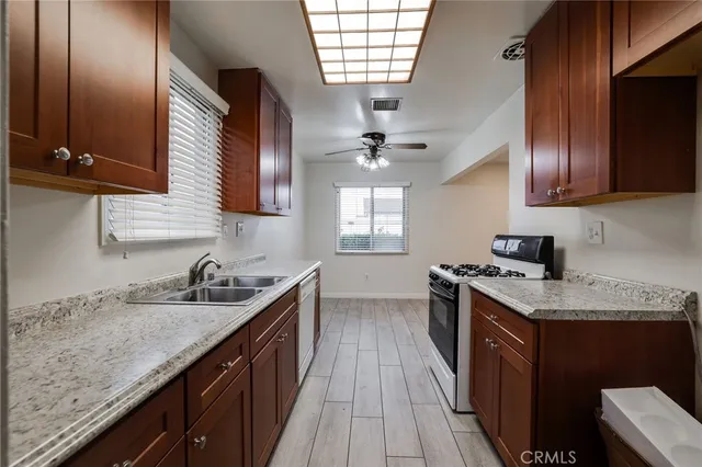 a kitchen with stainless steel appliances granite countertop a sink stove and cabinets