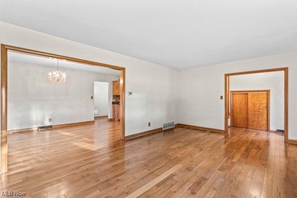 14413 Macklin Road New Springfield, OH 44443 - Photo 10 of 49 Spare room featuring light wood-type flooring and a chandelier