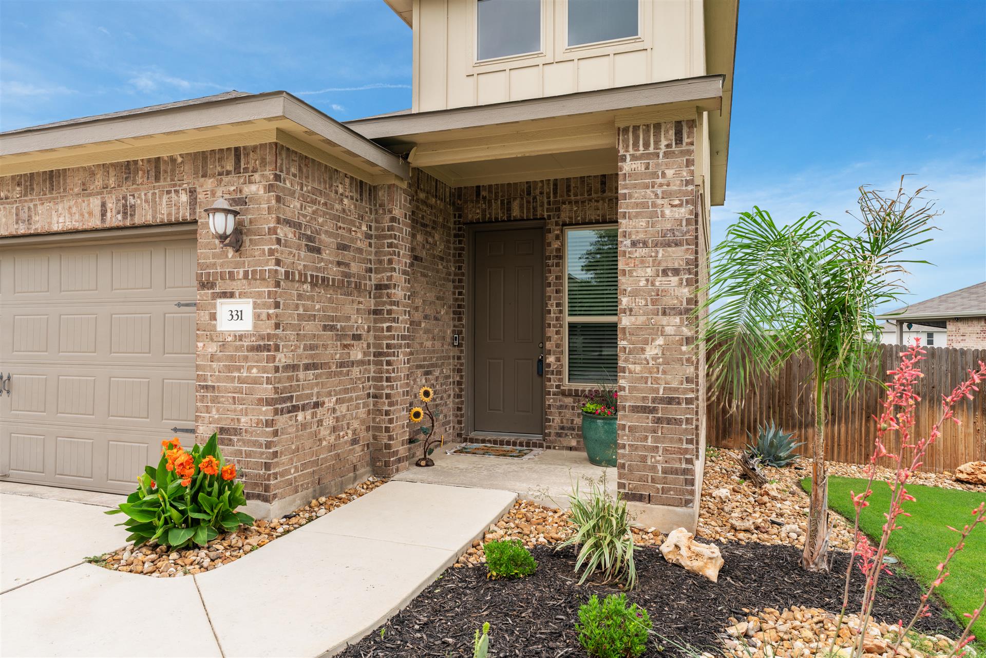 Brick exterior with an attached garage and covered entry