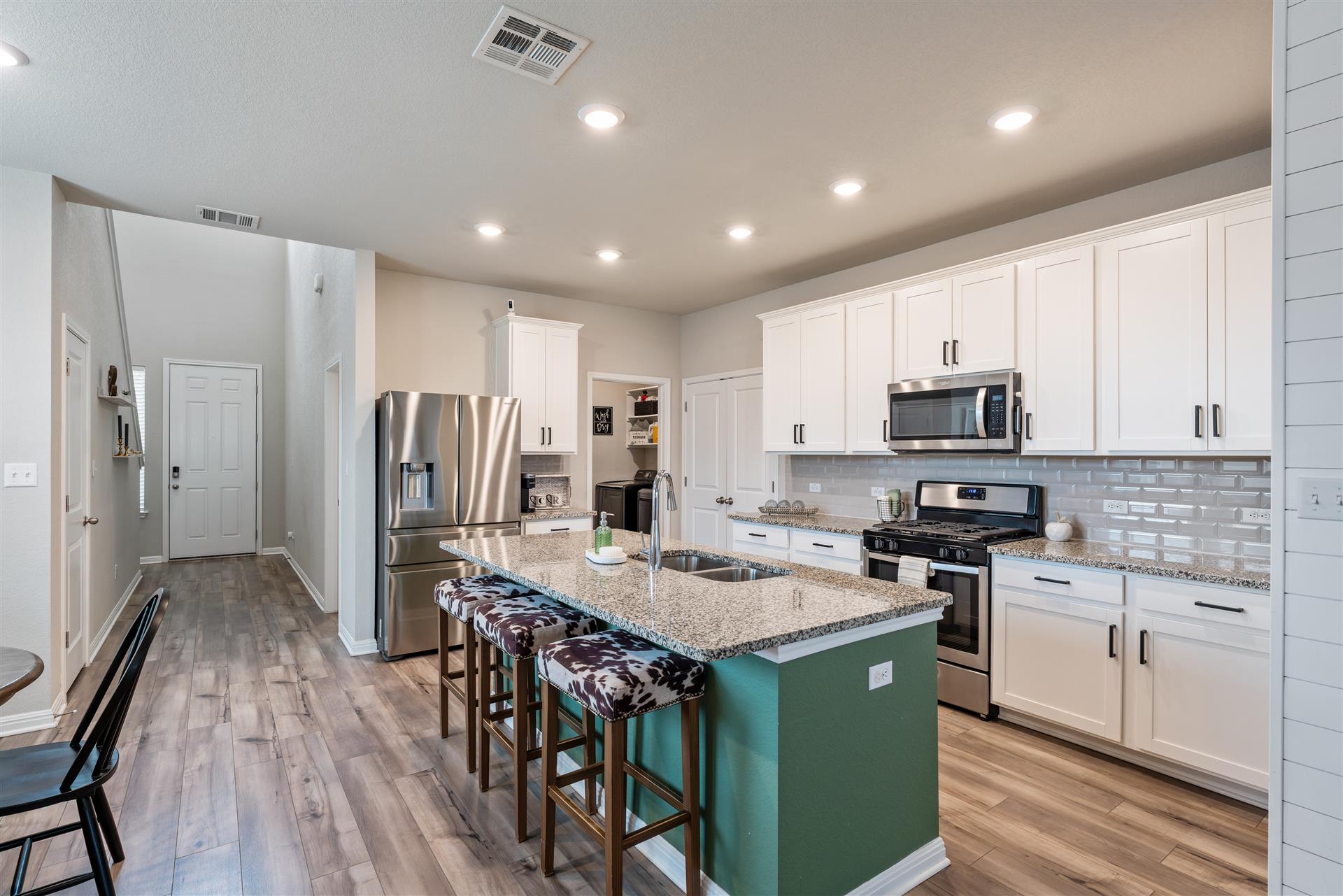 331 Mountain Valley Street Georgetown, TX 78628 - Photo 10 of 40 a kitchen with stainless steel appliances granite countertop a stove refrigerator sink and cabinets