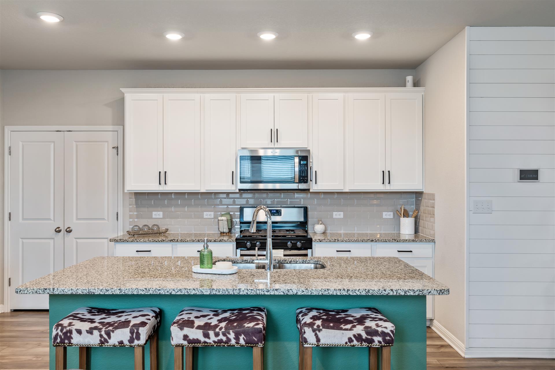 331 Mountain Valley Street Georgetown, TX 78628 - Photo 12 of 40 a kitchen with stainless steel appliances granite countertop a sink and white cabinets