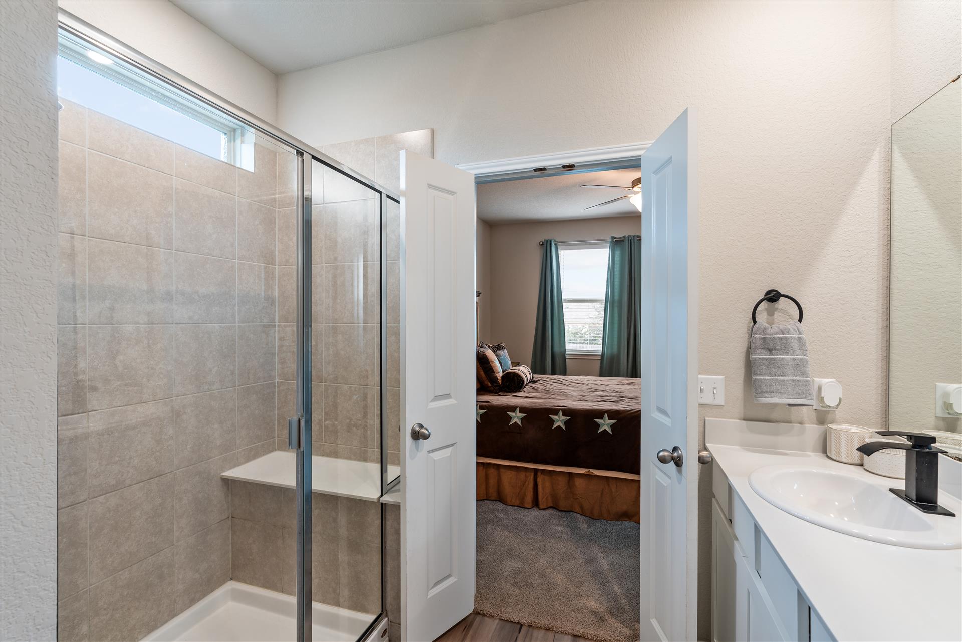 331 Mountain Valley Street Georgetown, TX 78628 - Photo 19 of 40 a en suite bathroom with a sink a mirror and a shower