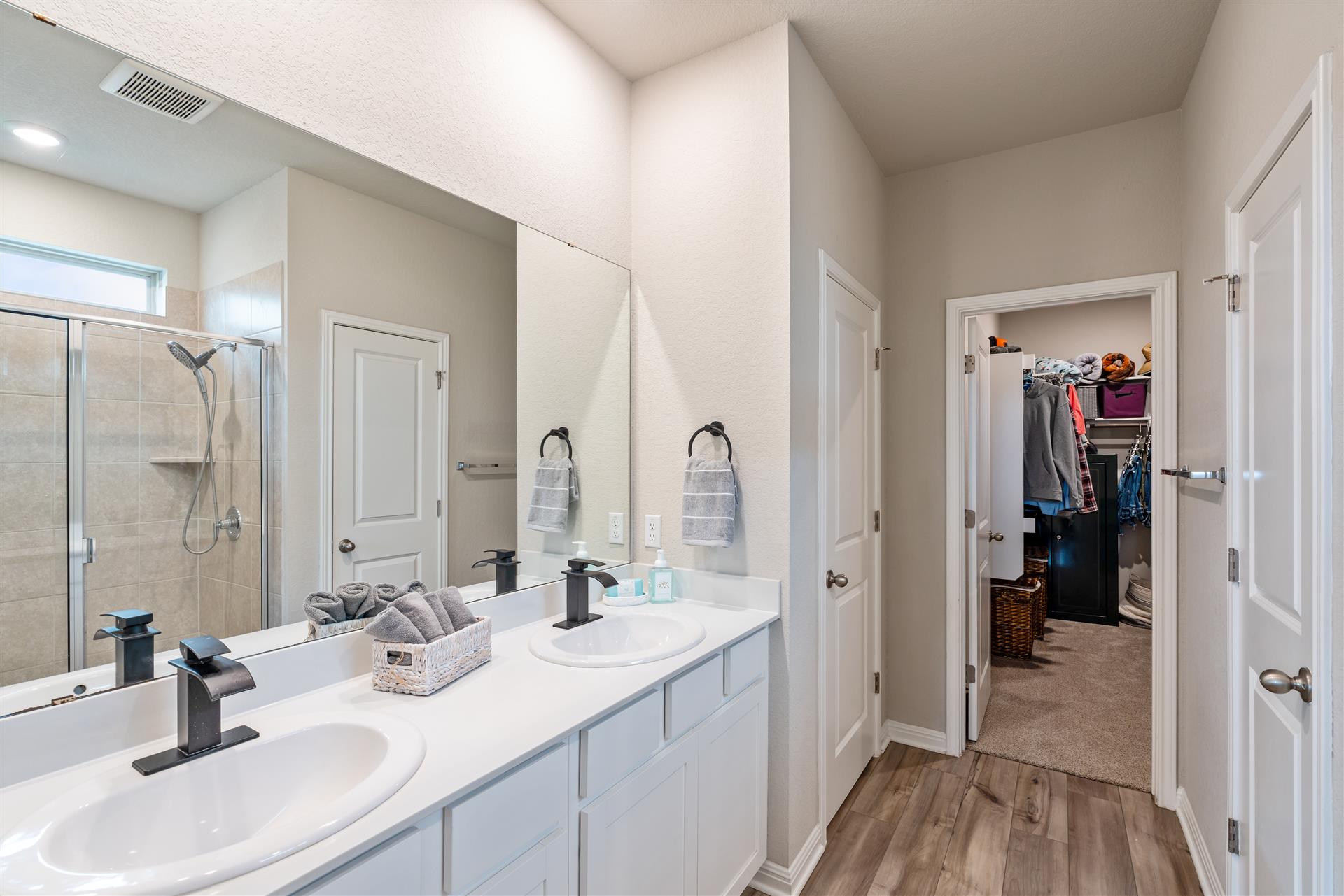 331 Mountain Valley Street Georgetown, TX 78628 - Photo 18 of 40 Owner ensuite bath featuring a shower, double vanity, light wood-style flooring, and a large walk in closet
