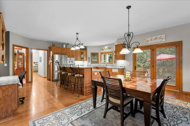 a dining room with furniture wooden floor a chandelier and a rug