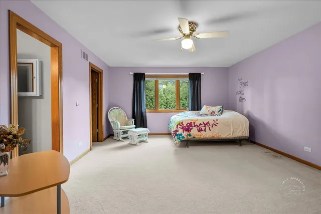 a bedroom with a bed a chandelier and a couch