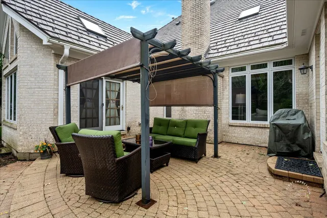 a view of a table and chairs in backyard under a umbrella
