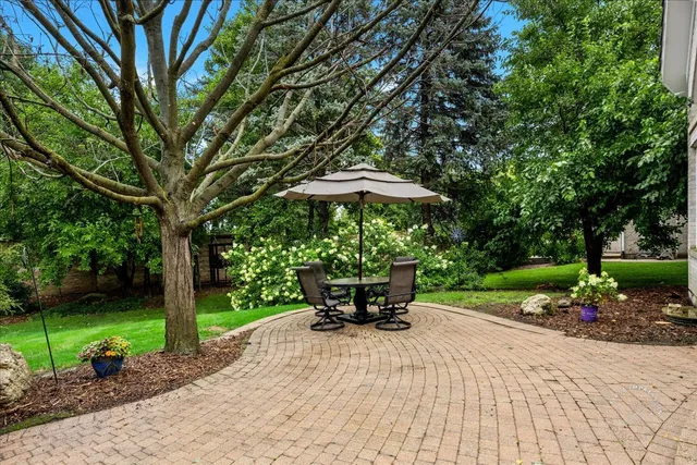 a view of a backyard with table and chairs under an umbrella