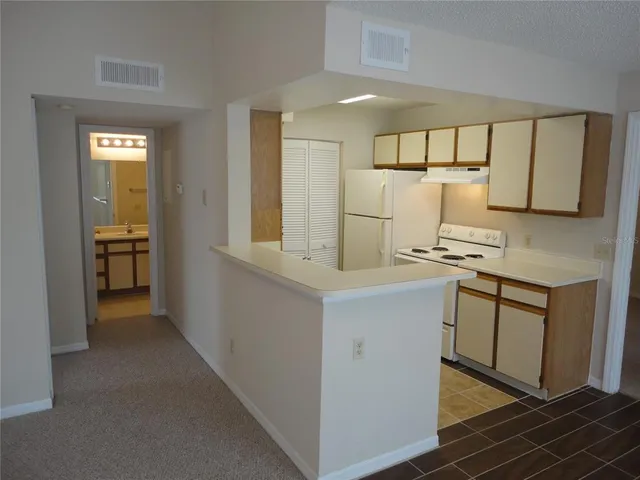 a kitchen with cabinets and wooden floor