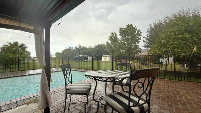 a view of a patio with a table chairs and a backyard