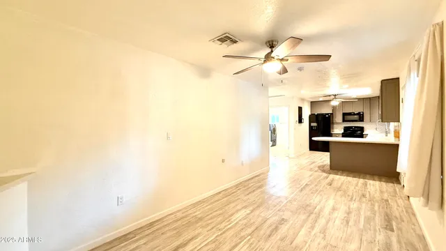 a view of a kitchen with wooden floor and a ceiling fan